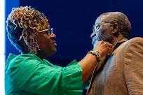 Renee Warren-Morrissette pins a Finance and Comptroller Hall of Fame regimental lapel pin on her husband, retired Command Sgt. Maj. Paul L. Morrissette, during a hall of fame induction ceremony at the Soldier Support Institute on Fort Jackson, South Carolina, April 26, 2024. Morrissette, a former Finance Corps regimental sergeant major, was made the third inductee of the hall of fame for his service and commitment to the U.S. Army Finance Corps for more than forty Years. (U.S. Army photo by Mark R. W. Orders-Woempner)