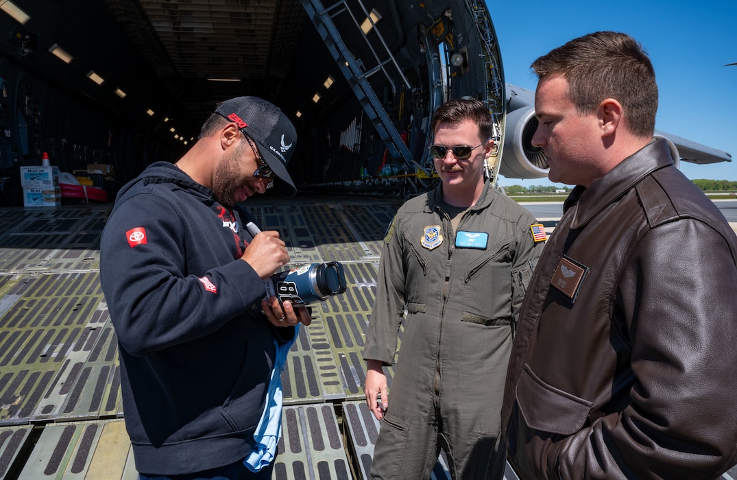 Bubba Wallace, left, Würth 400 NASCAR Cup Series driver, signs a water bottle after a tour of a U.S. Air Force C-5M Super Galaxy at Dover Air Force Base, Delaware, April 26, 2024. Wallace toured the C-5 during this visit to Dover AFB before the weekend’s race at Dover Motor Speedway. (U.S. Air Force photo by Airman 1st Class Amanda Jett)