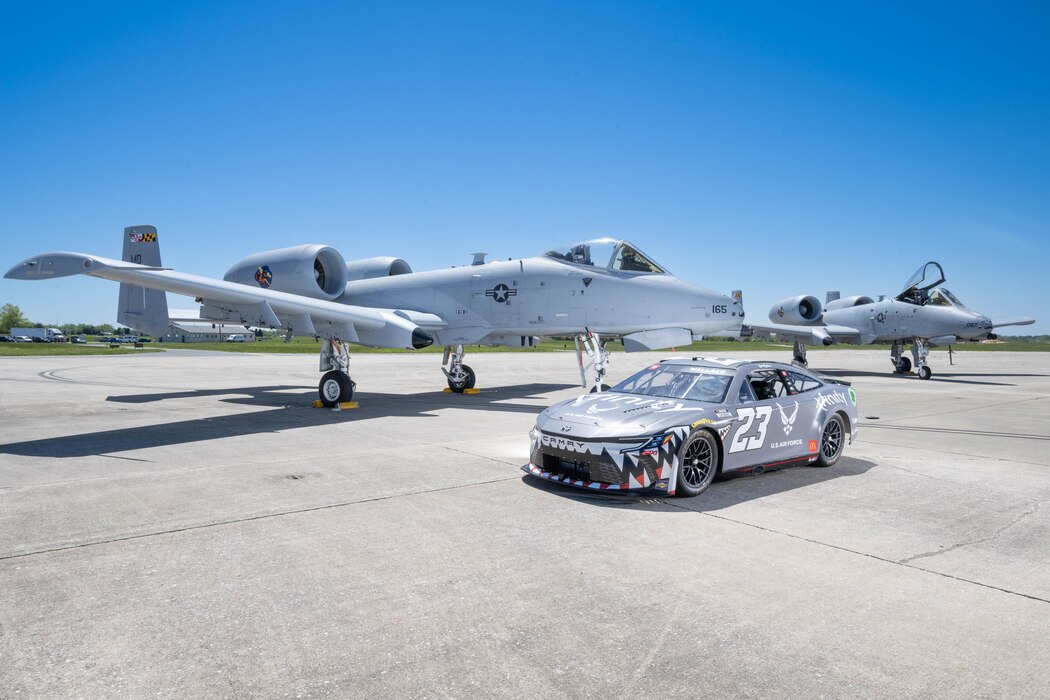 The Würth 400 NASCAR Cup Series No. 23 Toyota Camry sits with two U.S. Air Force A-10C Thunderbolt IIs on the flight line at Dover Air Force Base, Delaware, April 26, 2024. Bubba Wallace, the car’s driver, toured Dover AFB before the weekend’s race at Dover Motor Speedway. (U.S. Air Force photo by Mauricio Campino)