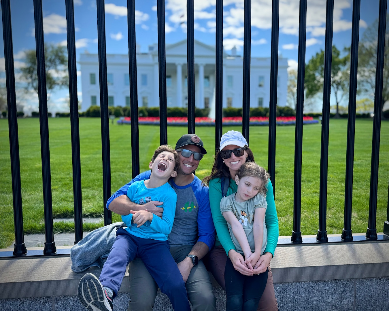 A family of four poses for a portrait outside the White House