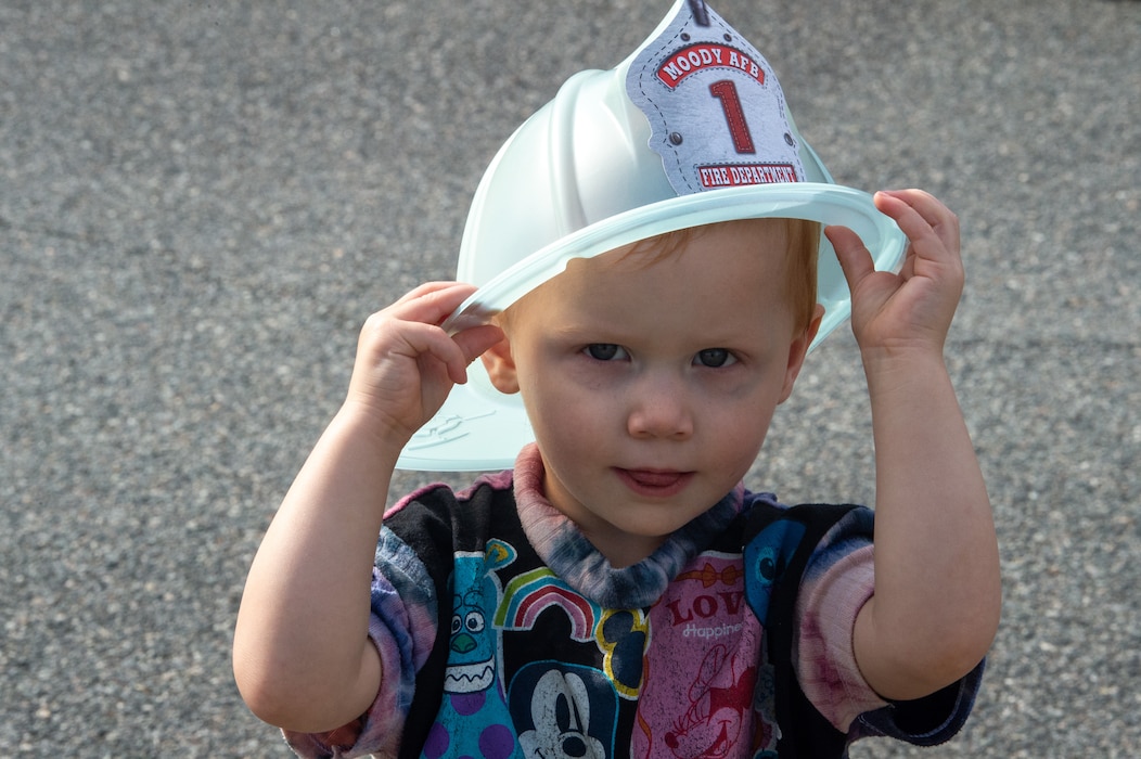 Photo of child wearing a toy firefighter helmet