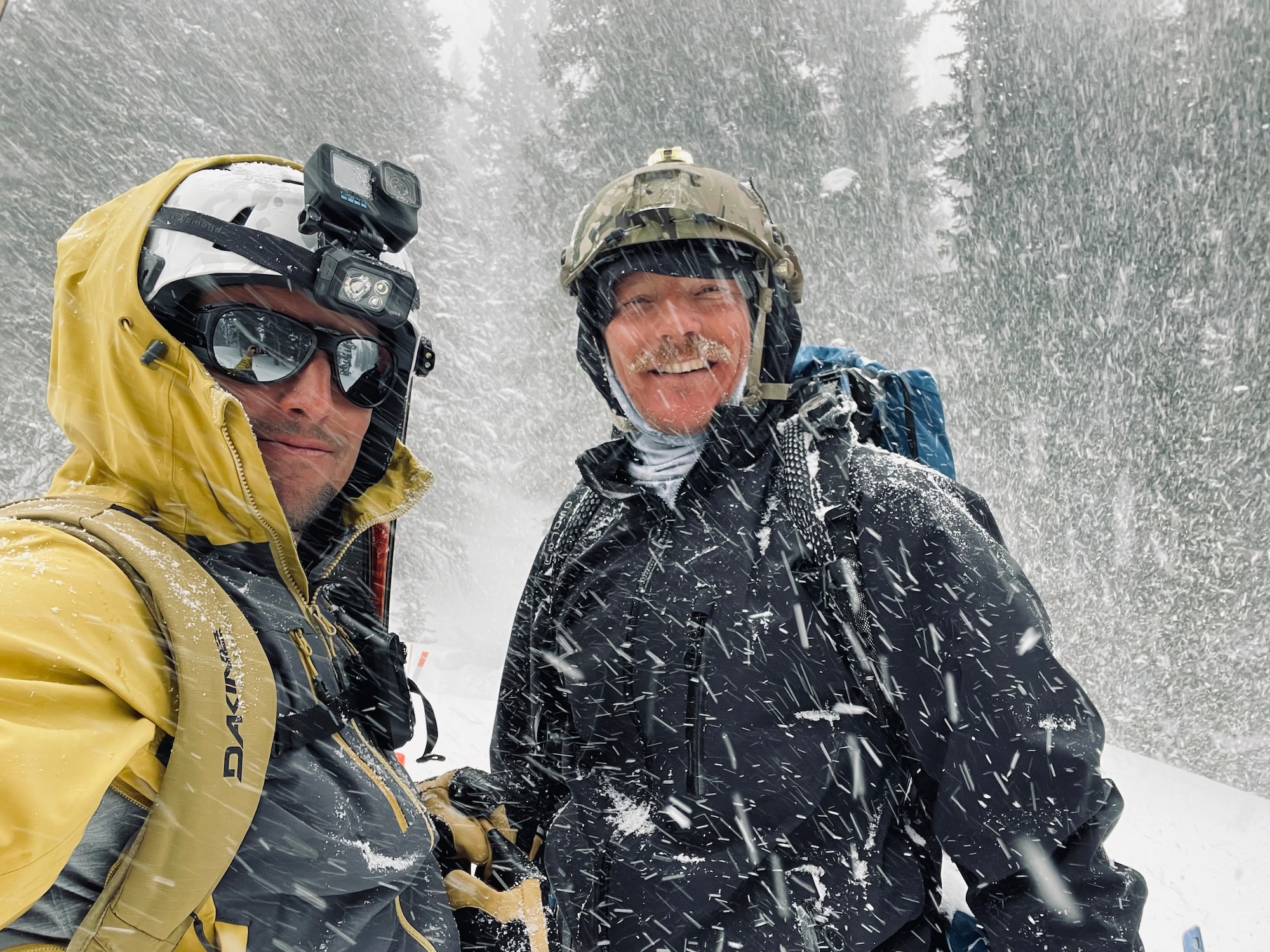 Two men pose for a picture in the snow