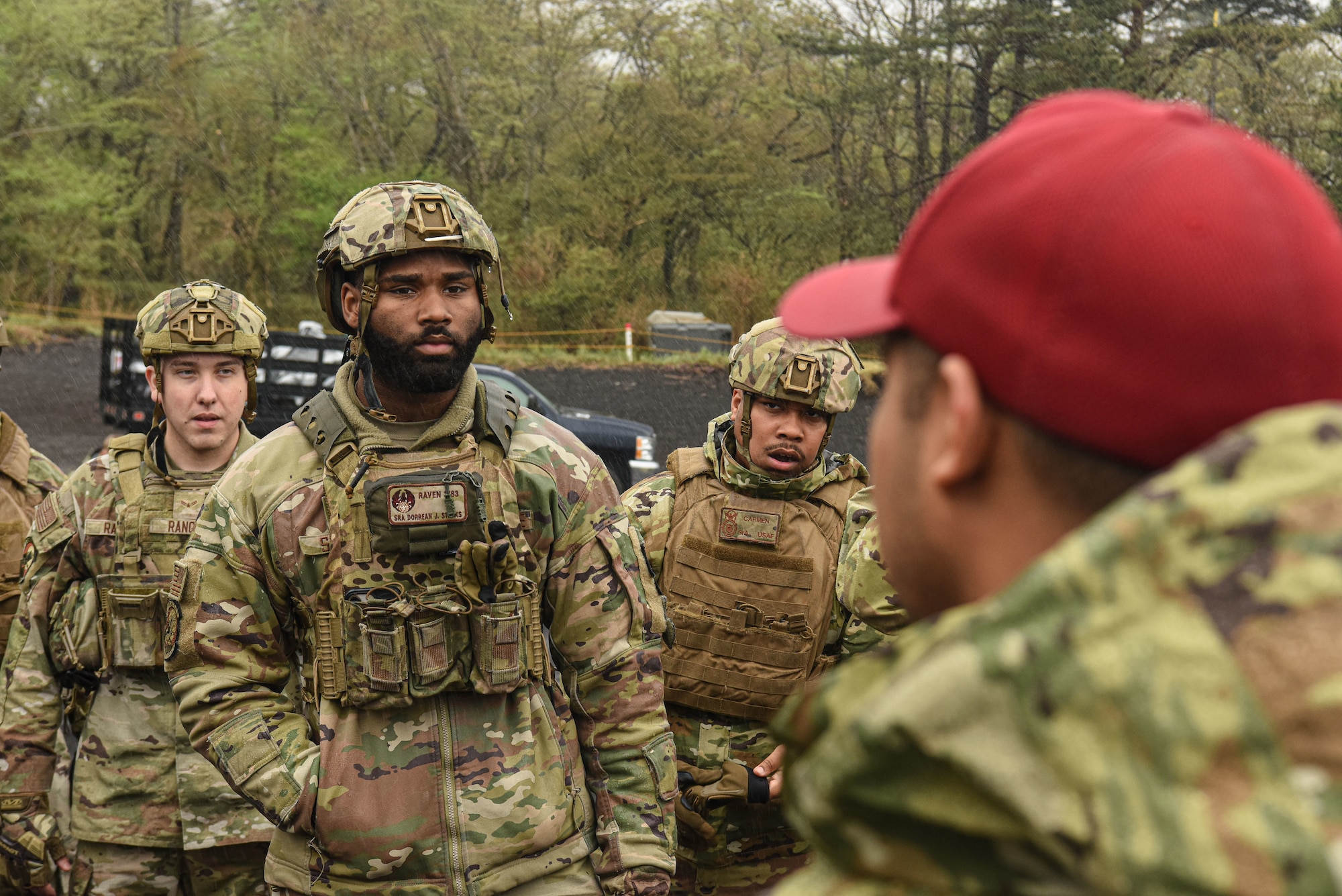 U.S. servicemembers listen as they receive a briefing from a combat arms instructor.