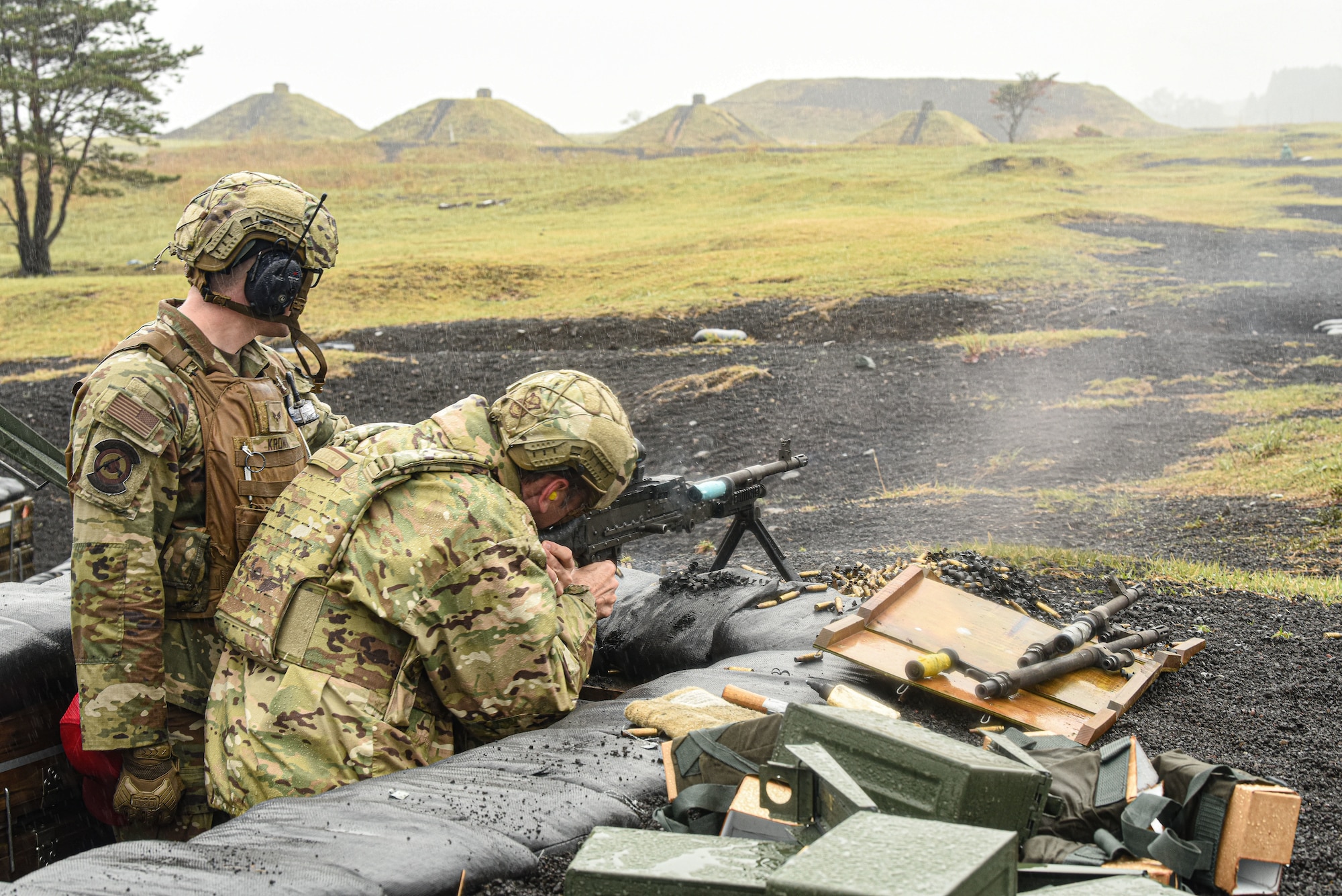 U.S. military personnel fire a machine gun on a weapons range.