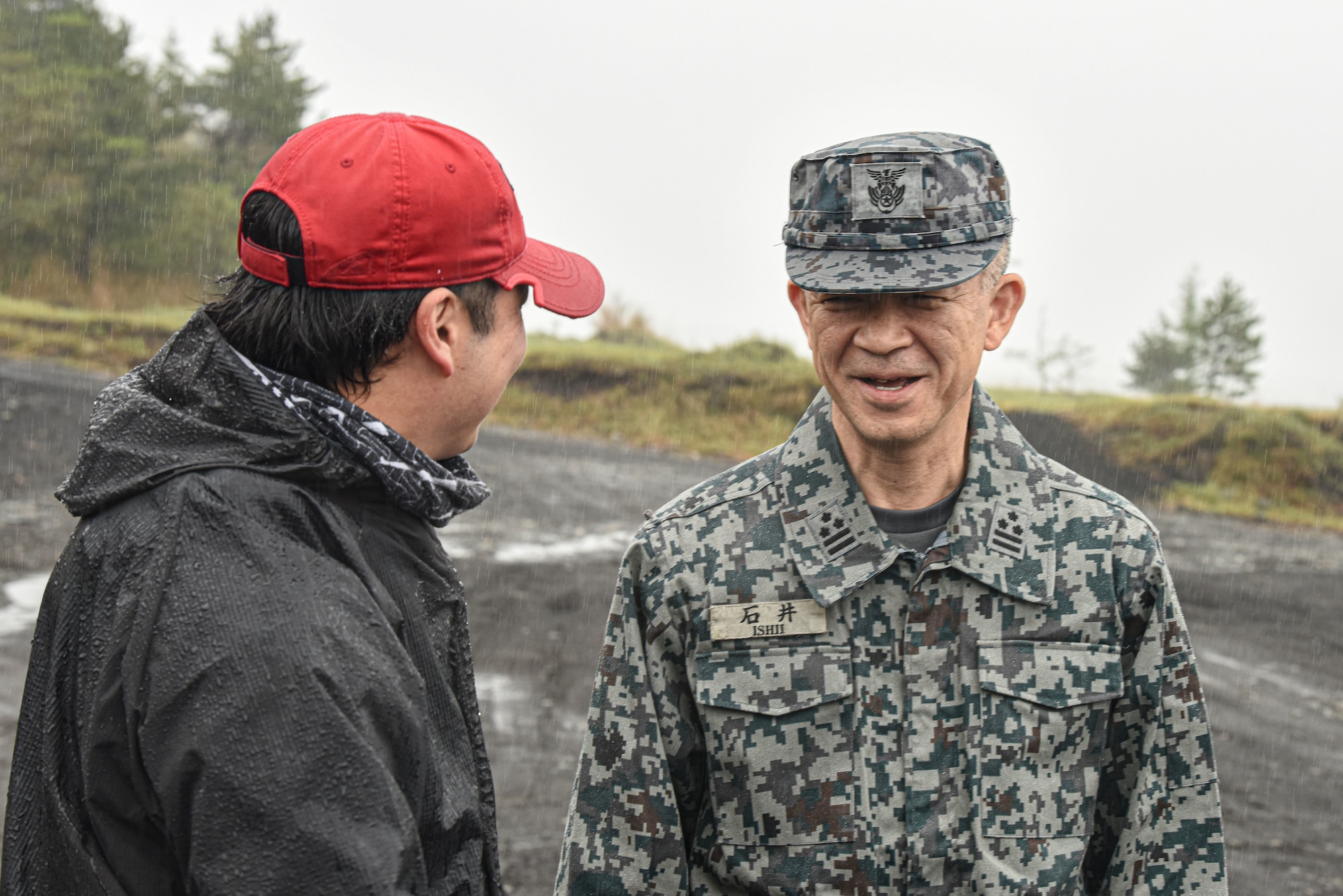 A Japan Air Self-Defense Force servicemember speaks with a weapons instructor.