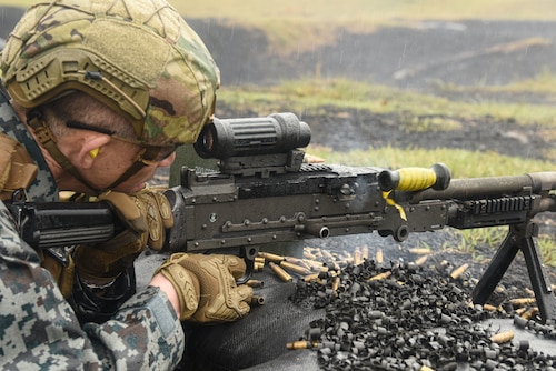 The Japan Air Self-Defense Force Operations Support Wing commander fires a machine gun.