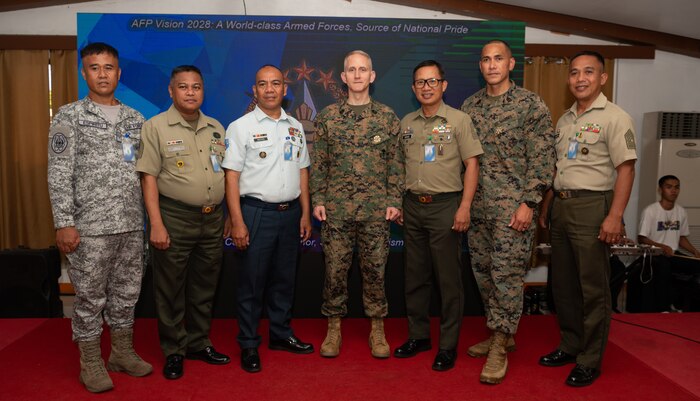 Armed Forces of the Philippines and U.S. Marine Corps service members pose for a photo at the Civil-Military Operations subject matter expert exchange during Exercise Balikatan 24 at Camp Aguinaldo, Philippines, April 29, 2024. AFP and U.S. military CMO specialists joined together to share the best civil affairs practices and their experiences when military forces were called to support civilian populations during the COVID-19 pandemic, natural disasters, and refugee crises. BK 24 is an annual exercise between the Armed Forces of the Philippines and the U.S. military designed to strengthen bilateral interoperability, capabilities, trust, and cooperation built over decades of shared experiences. (U.S. Air Force photo by Staff Sgt. Pedro Tenorio) (This photo has been altered for security purposes by blurring out identification badges.)