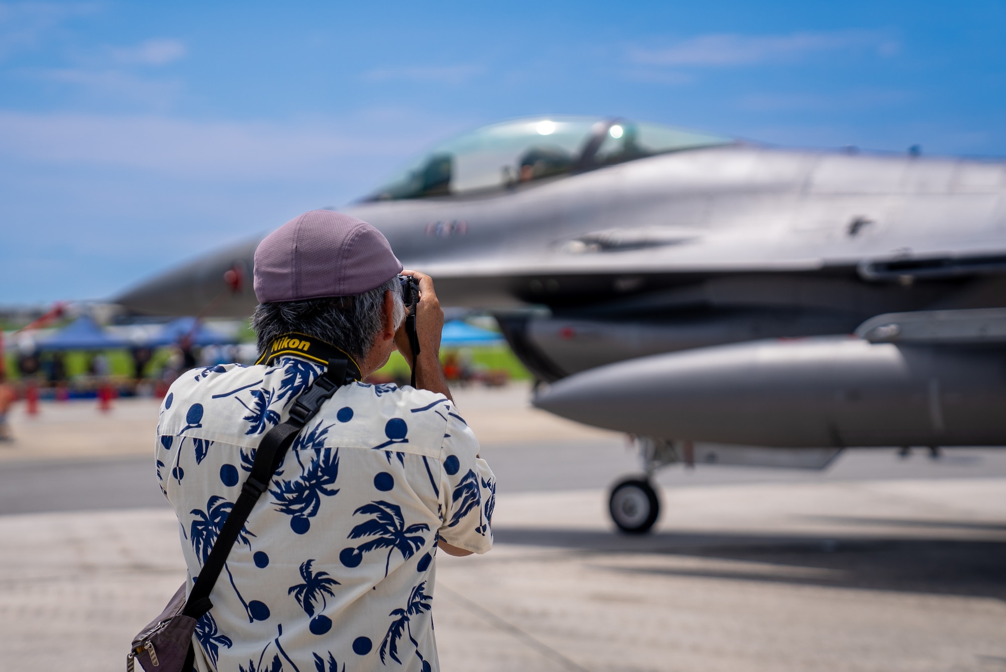 A festival attendee takes a photograph of a static display aircraft during America Fest at Kadena Air Base, Japan, April 27, 2024.