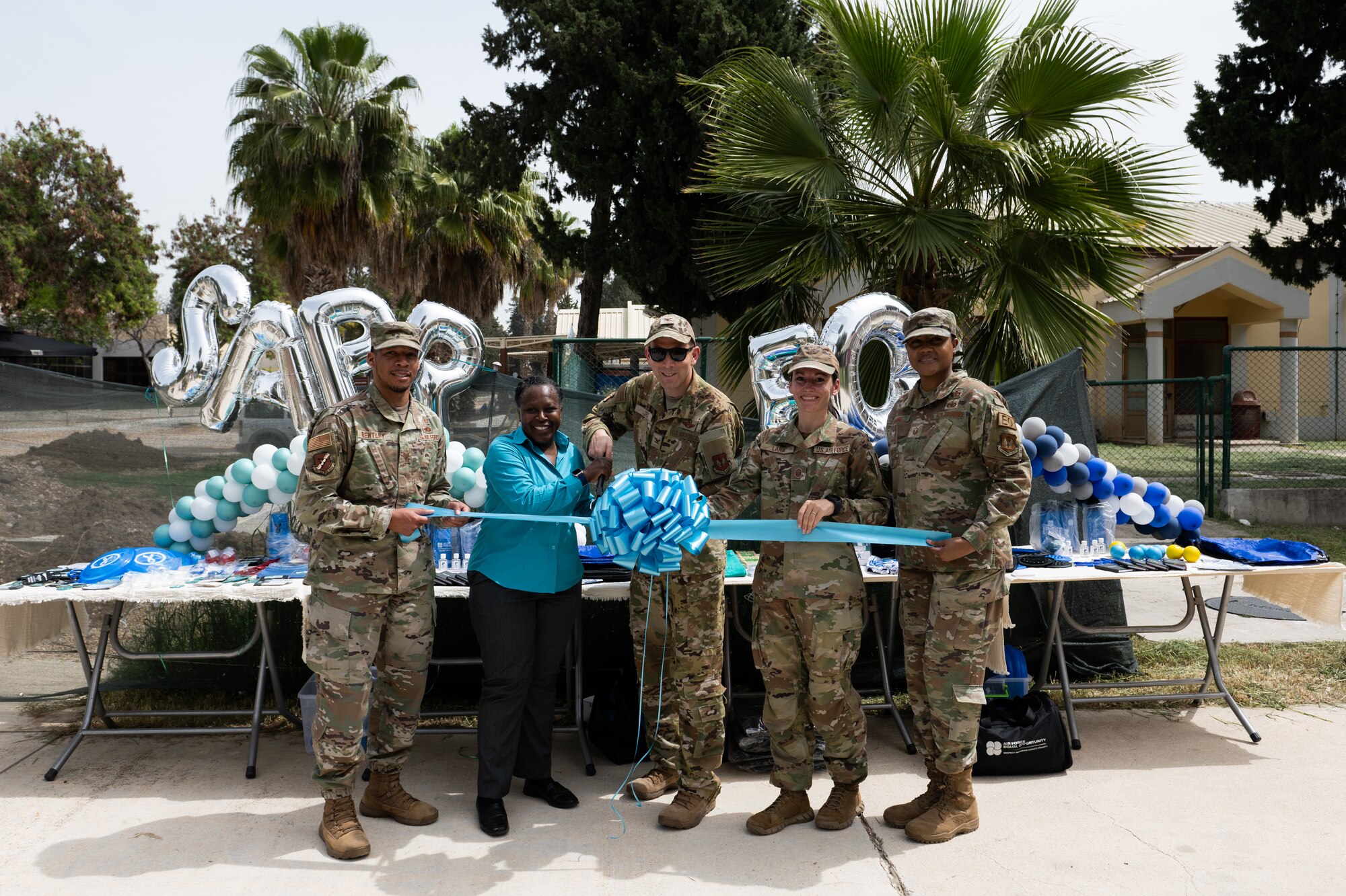 U.S Air Force members pose for a photo during the grand reopening and ribbon cutting of the Equal Opportunity and Sexual Assault Prevention and Response building.