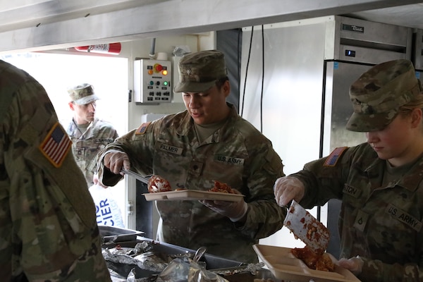 Spc. Tyler Palmer, a culinary specialist with Echo Company, 700th Brigade Support Battalion, 45th Infantry Brigade Combat Team, serves lunch to a competitor from the Best Warrior Competition during the inaugural OKARNG Culinary Excellence Challenge at Camp Gruber Training Center, April 27, 2024. The OKARNG hosted its inaugural state-level culinary competition to bring Soldiers together to demonstrate their proficiency in a variety of culinary tasks and drills, fostering a culture of esprit de corps, resiliency, and personal growth for OKARNG Culinary Specialists. (Oklahoma National Guard photo by Sgt. Elliott Kim)