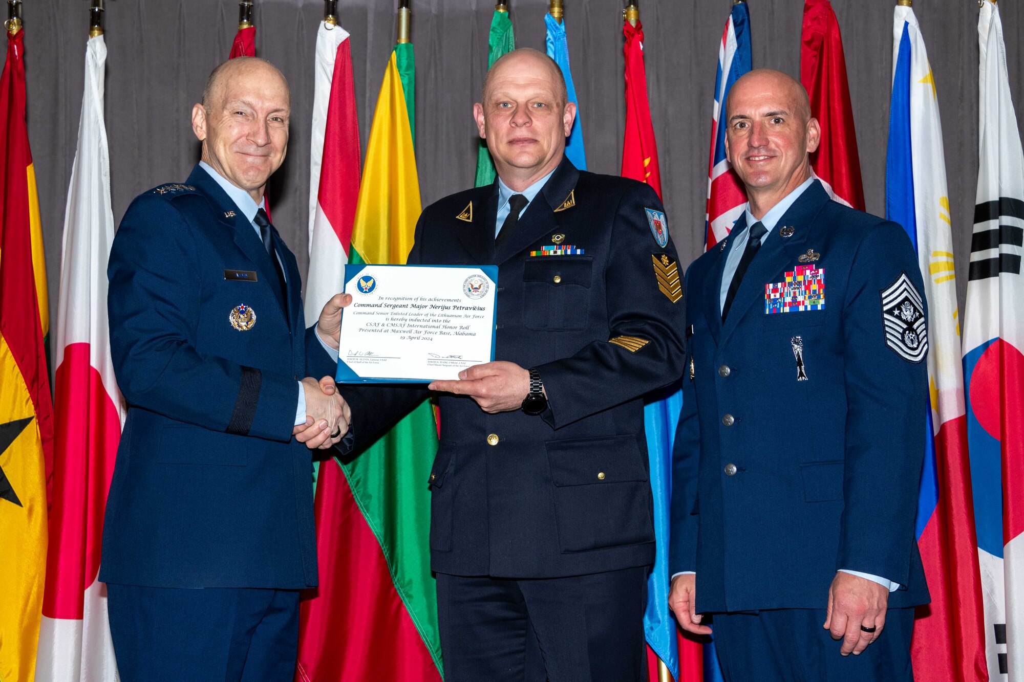 Air Force Chief of Staff Gen. David Allvin and Chief Master Sergeant of the Air Force David Flosi induct Command Sergeant Major Nerijus Petravičius, Command Senior Enlisted Advisor of the Lithuanian Air Force, into the 2024 CSAF & CMSAF International Honor Roll at Maxwell Air Force Base, Ala., Apr. 19, 2024. International Honor Roll recognizes former Air University students who rose to the equivalent level of Chief of Staff or higher or Chief Master Sergeant of the Air Force or higher in their respective services. (US Air Force photo by Melanie Rodgers Cox)