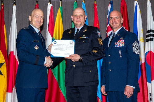 Air Force Chief of Staff Gen. David Allvin and Chief Master Sergeant of the Air Force David Flosi induct Command Sergeant Major Nerijus Petravičius, Command Senior Enlisted Advisor of the Lithuanian Air Force, into the 2024 CSAF & CMSAF International Honor Roll at Maxwell Air Force Base, Ala., Apr. 19, 2024. International Honor Roll recognizes former Air University students who rose to the equivalent level of Chief of Staff or higher or Chief Master Sergeant of the Air Force or higher in their respective services. (US Air Force photo by Melanie Rodgers Cox)