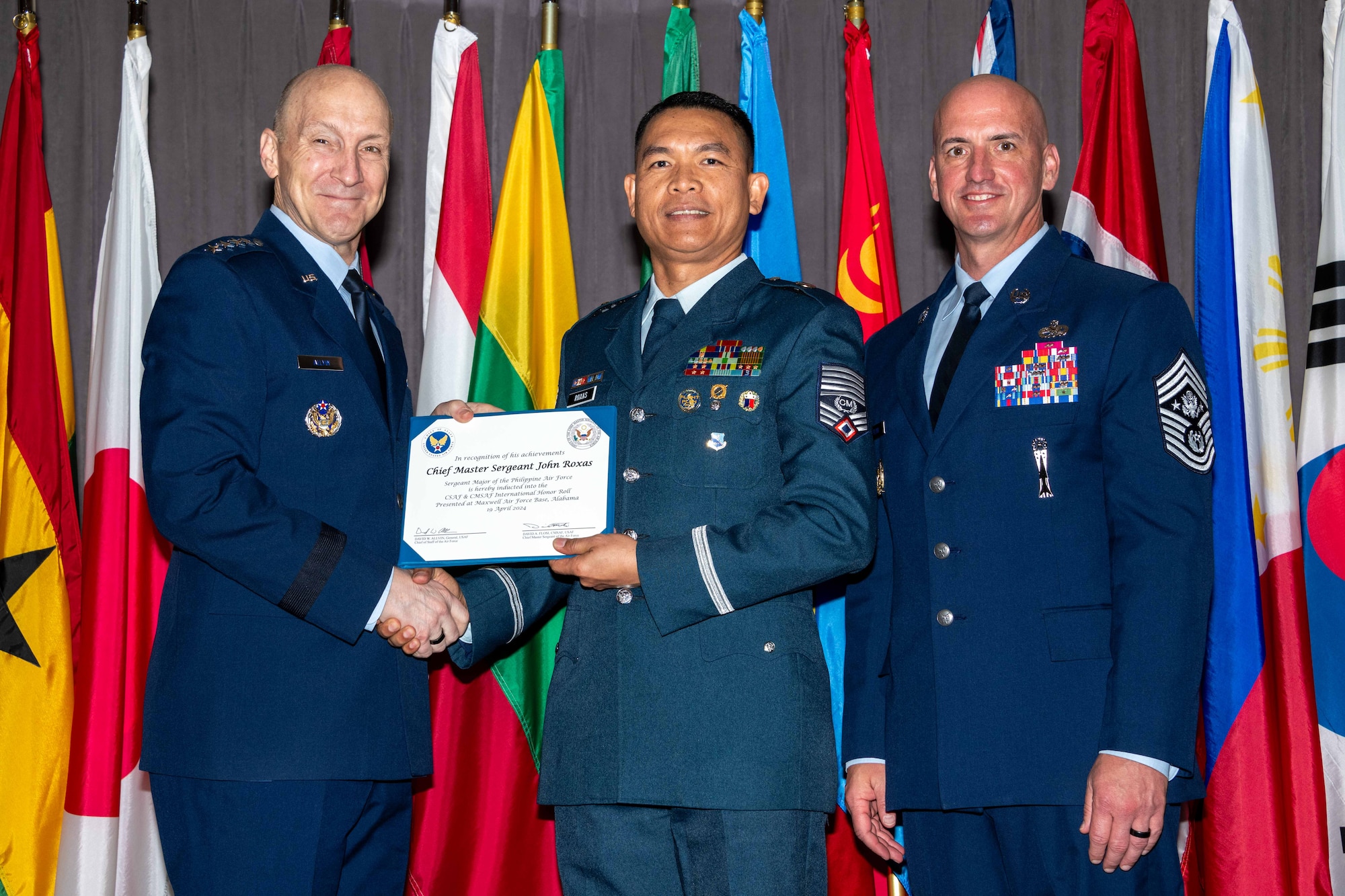 Air Force Chief of Staff Gen. David Allvin and Chief Master Sergeant of the Air Force David Flosi induct Chief Master Sgt. John Roxas, Sergeant Major of the Philippine Air Force, into the 2024 CSAF & CMSAF International Honor Roll at Maxwell Air Force Base, Ala., Apr. 19, 2024. International Honor Roll recognizes former Air University students who rose to the equivalent level of Chief of Staff or higher or Chief Master Sergeant of the Air Force or higher in their respective services. (US Air Force photo by Melanie Rodgers Cox)