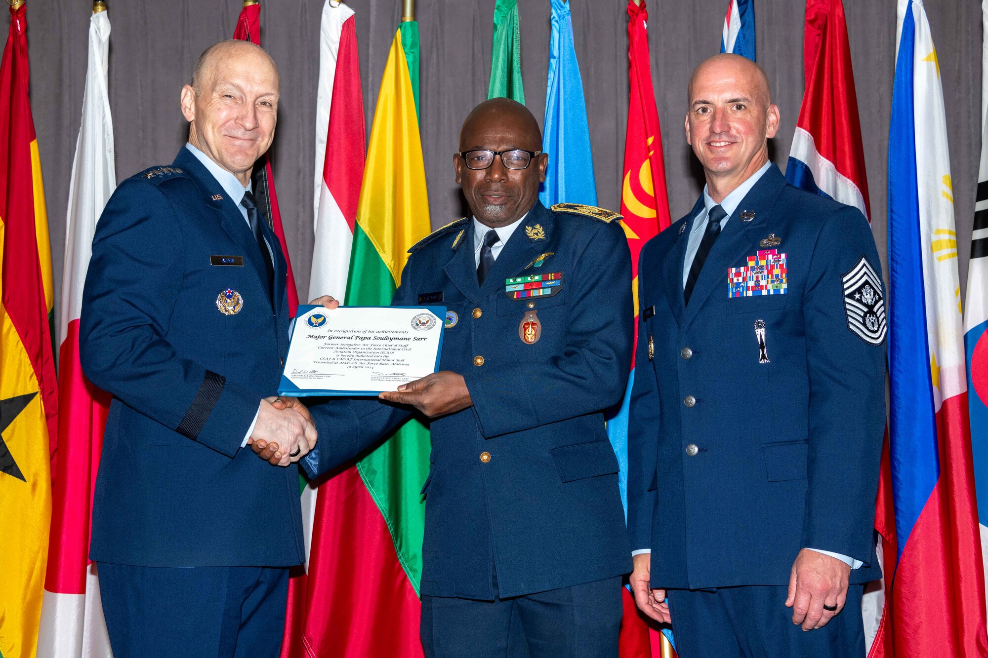 Air Force Chief of Staff Gen. David Allvin and Chief Master Sergeant of the Air Force David Flosi induct Maj. Gen. Papa Souleymane Sarr, former Senegalese Air Force Chief of Staff, into the 2024 CSAF & CMSAF International Honor Roll at Maxwell Air Force Base, Ala., Apr. 19, 2024. Sarr is the current Ambassador to International Civil Aviation Organization (ICAO), Montreal, Canada. International Honor Roll recognizes former Air University students who rose to the equivalent level of Chief of Staff or higher or Chief Master Sergeant of the Air Force or higher in their respective services. (US Air Force photo by Melanie Rodgers Cox)