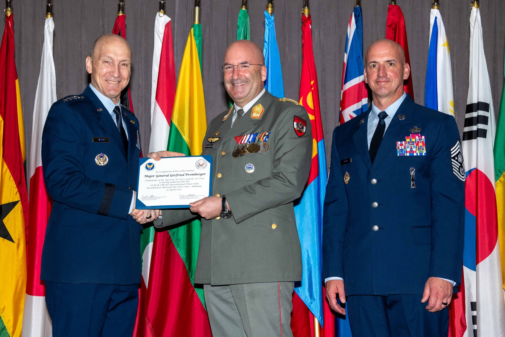 Air Force Chief of Staff Gen. David Allvin and Chief Master Sergeant of the Air Force David Flosi induct Maj. Gen. Gerfried Promberger, Commander and the Air Chief of the Austrian Air Force, into the 2024 CSAF & CMSAF International Honor Roll at Maxwell Air Force Base, Ala., Apr. 19, 2024. International Honor Roll recognizes former Air University students who rose to the equivalent level of Chief of Staff or higher or Chief Master Sergeant of the Air Force or higher in their respective services. (US Air Force photo by Melanie Rodgers Cox)