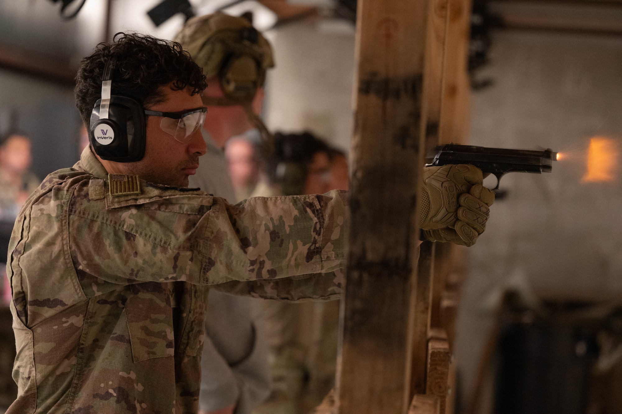 Senior Airman Derrick Medina fires his M9 Barretta at a target downrange.