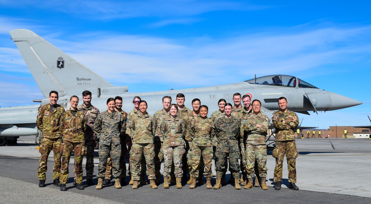 Service members from the Italian Air Force, U.S. Marine Corps, and U.S. Air Force pose for a photo during an exercise.