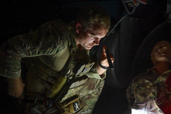 An Airman looks at a training mannequin