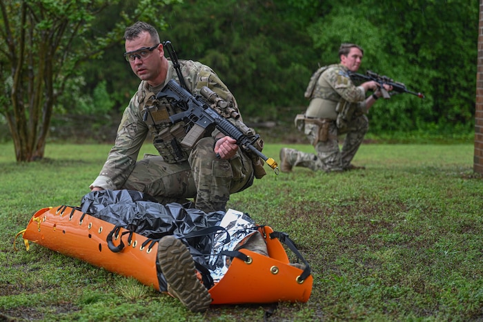 An Airman covers a patient with a blanket