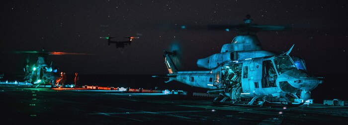 240406-M-YF186-2166 PACIFIC OCEAN (April 6, 2024) U.S. Marine Corps UH-1Y Venoms attached to Medium Tiltrotor Squadron (VMM) 165 (Reinforced), 15th Marine Expeditionary Unit, prepare for take-off while an MV-22B Osprey flies toward the amphibious assault ship USS Boxer (LHD 4) in the Pacific Ocean April 6, 2024. The Venoms conducted a helicopter insert for Marines assigned to Reconnaissance Company, 15th MEU, performing a reconnaissance and surveillance mission for a raid exercise ashore. Elements of the 15th MEU are currently embarked aboard the Boxer Amphibious Ready Group conducting routine operations in U.S. 3rd Fleet. (U.S. Marine Corps photo by Cpl. Joseph Helms)