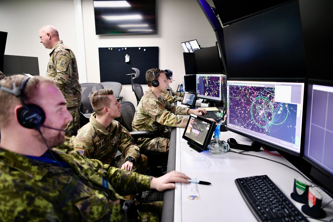 Men looking at computer screens.