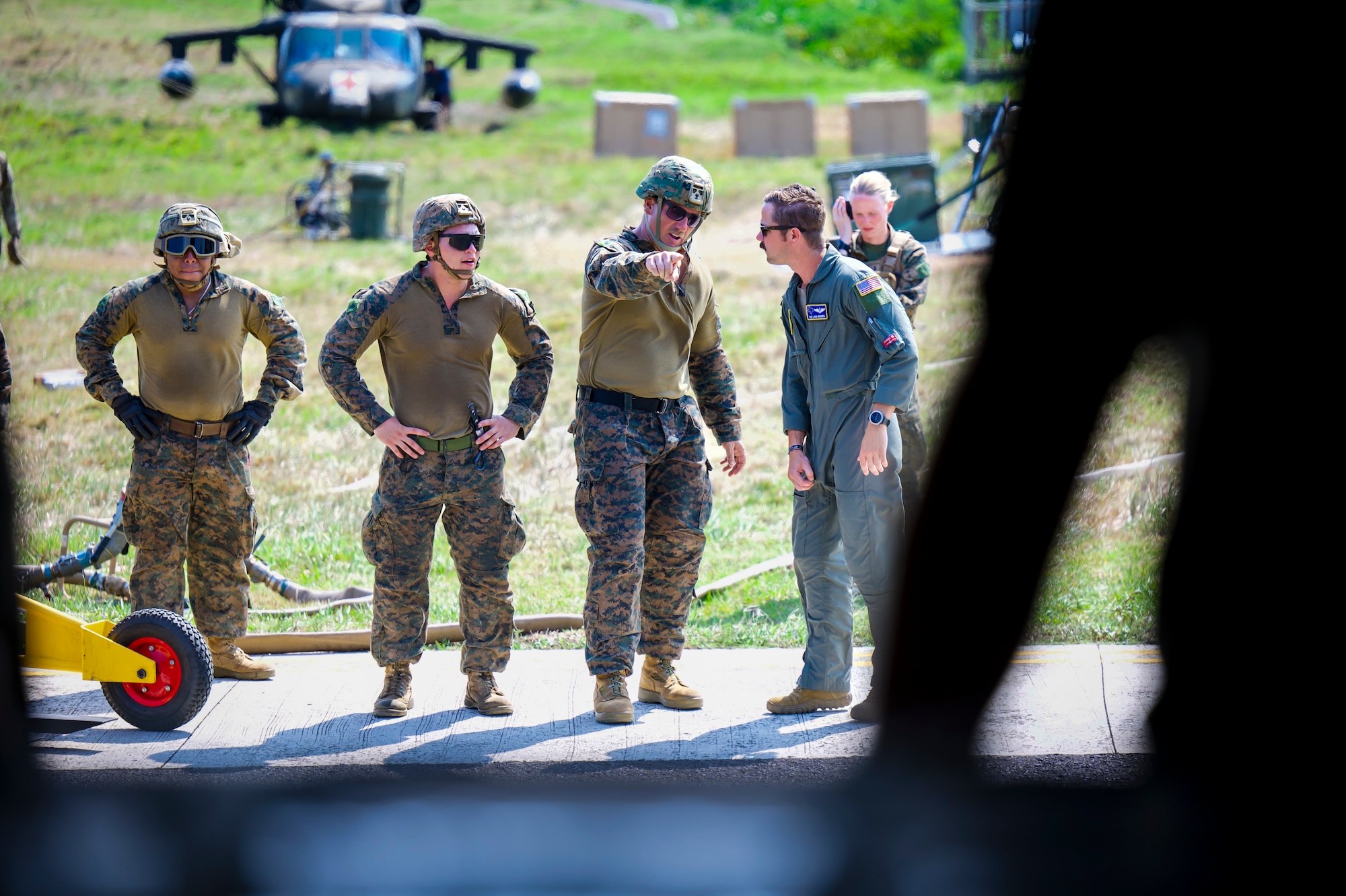 U.S. Marines discuss how to offload cargo with U.S. Air Force Tech Sgt. Joshua Bredwell, 40th Airlift Squadron loadmaster, during Exercise Balikatan 24 at Basco Airfield, Philippines.
