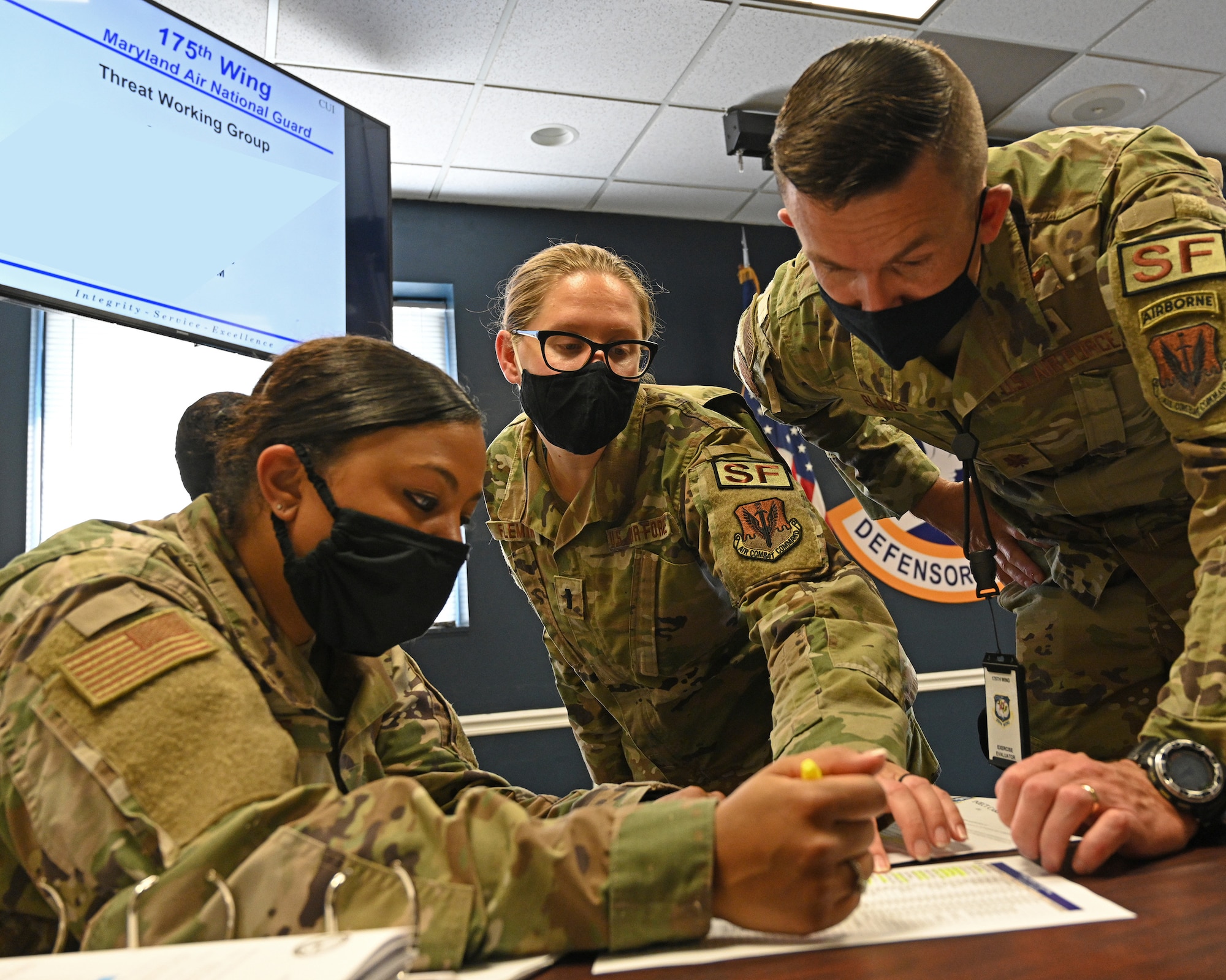 U.S. Air Force Master Sgt. Desiree Hayes (left), 175th Wing anti-terrorism program mananger, and U.S. Air Force 1st Lt. Allison Fleming (middle), 175th Wing anti-terrorism officer, discuss the details of an active shooter exercise scenario with U.S. Air Force Maj. Zachary Blades (right), 175th Security Forces Squadron commander, during an active shooter exercise at Warfield Air National Guard Base at Martin State Airport, Middle River, Md., August 26, 2021.