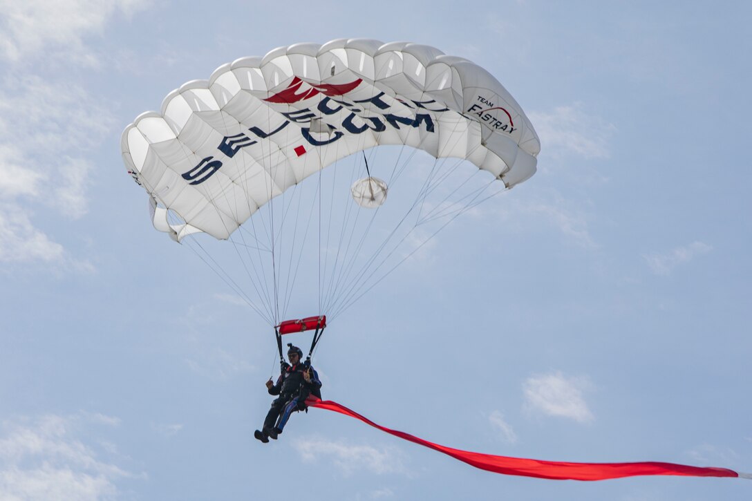 Matt Harvey, a member of Team Fastrax, parachutes down with a 200-foot red and white streamer during the 45th Friendship Day at Marine Corps Air Station Iwakuni, Japan, May 5, 2024. Since 1973, MCAS Iwakuni has held a Friendship Day open house to foster positive relationships between the air station and its Japanese hosts, offering a culturally enriching experience that displays the mutual support the U.S. and Japan share. (U.S. Marine Corps photo by Lance Cpl. Dahkareo Pritchett)