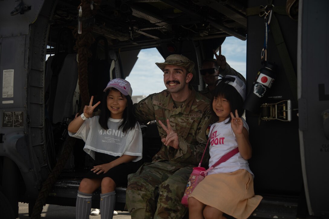 U.S. Air Force Senior Airman Carter Liwosz, an avionics specialist and native of Montana assigned to 33rd Rescue Squadron, Kadena Air Base, poses for a photo with guests inside of a HH-60W Pave Hawk during Marine Corps Air Station Iwakuni’s 45th Friendship Day at MCAS Iwakuni, Japan, May 5, 2024. Since 1973, MCAS Iwakuni has held a Friendship Day open house to foster positive relationships between the air station and its Japanese hosts, offering a culturally enriching experience that displays the mutual support the U.S. and Japan share. (U.S. Marine Corps photo by Lance Cpl. Rylan Adcock)