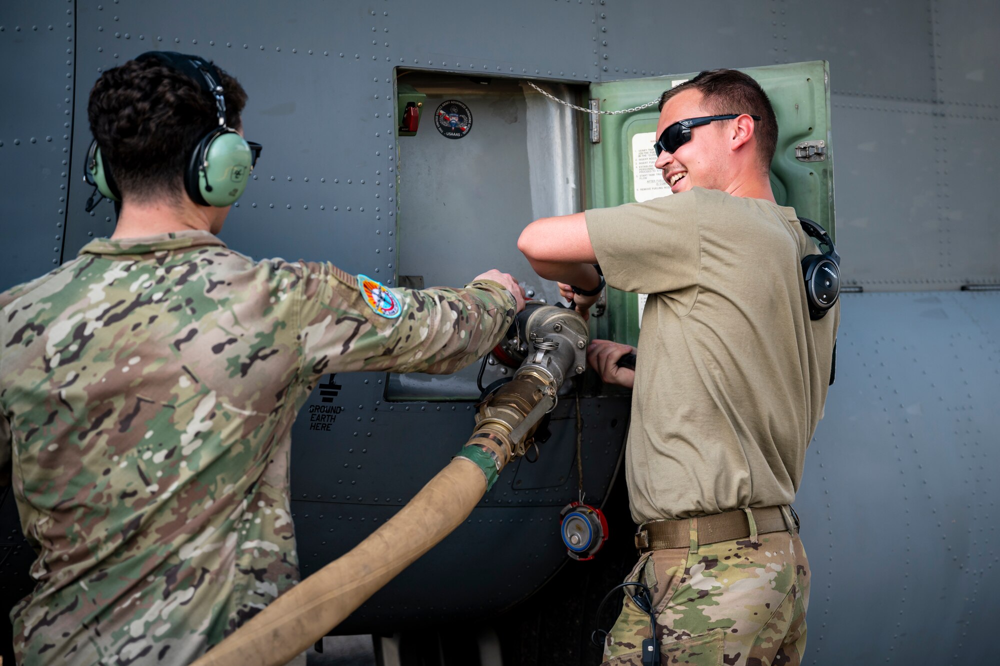 U.S. Air Force loadmaster and crew chief disconnect a fuel hose from a C-130J Hercules after providing fuel to a forward arming and refueling point site established by U.S. Marine Corps members.