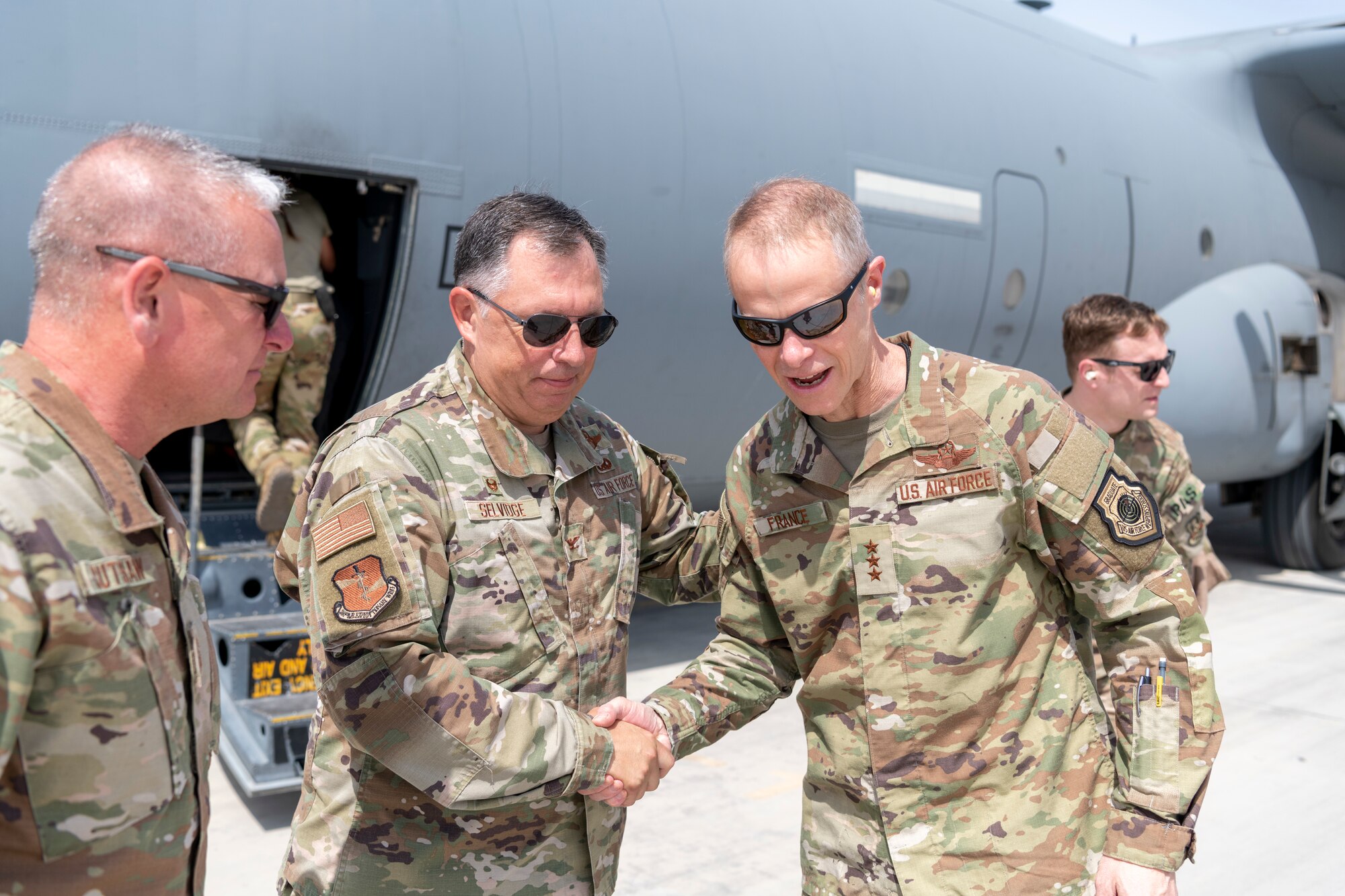 U.S. Air Force Lt. Gen. Derek France, Ninth Air Force commander, shakes hands with Col. Ronald Selvidge, 380th Air Expeditionary Wing commander, during a visit to the 380th AEW at an undisclosed location within the U.S. Central Command area of responsibility, April 29, 2024. France, who recently took command of Ninth Air Force, visited the wing to get a better understanding of its current operational capabilities, better enabling him to make informed decisions throughout the region. (U.S. Air Force photo)