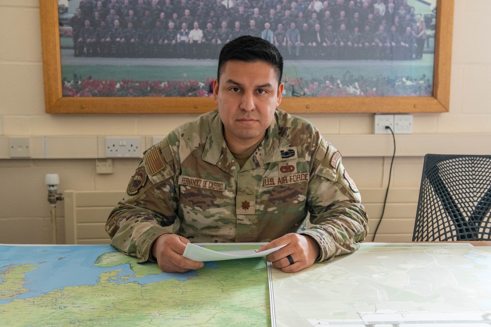 Airman sits at a conference table while holding papers