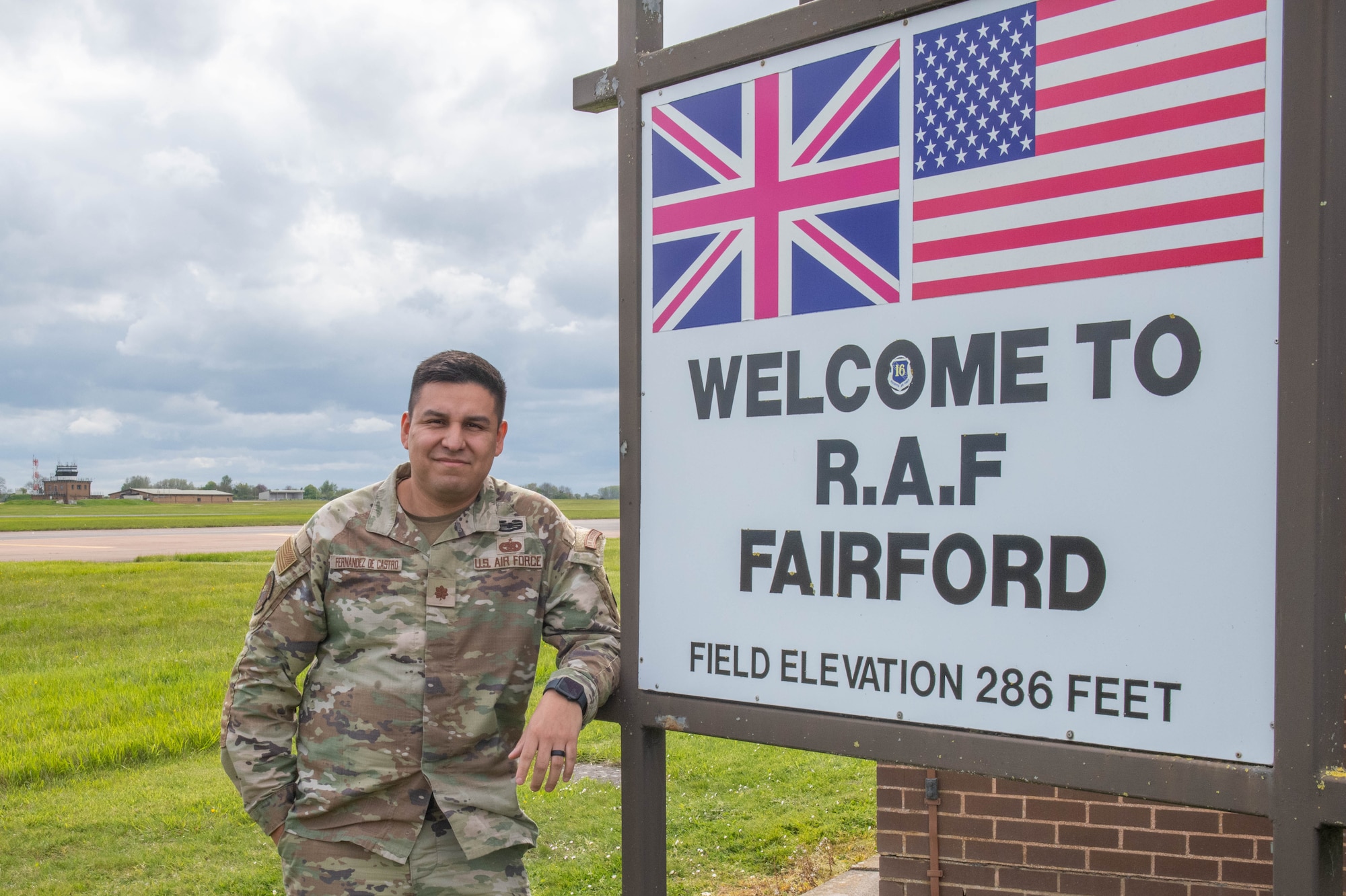 Airman stand next to a sign that reads "Welcome to RAF Fairford"