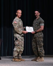 Command Sgt. Major Lee Strong, command sergeant major of the U.S. Army John F. Kennedy Special Warfare and School, presents an Army Commendation Medal to Hospital Corpsman 1st Class Michael O’Connell, a special operations independent duty corpsman and instructor with the Naval Special Operations Medical Institute at the Joint Special Operations Medical Training Center, during an awards ceremony for the school’s Best Warrior Competition at Fort Liberty, North Carolina, April 19, 2024. O’Connell was the only Navy competitor and took first place in the noncommissioned officer category of the competition, which challenges the competitors on various Soldier tasks including land navigation, oral board, swim test, ruck march, cognitive test, obstacle course and written exam. (U.S. Army photo by K. Kassens)