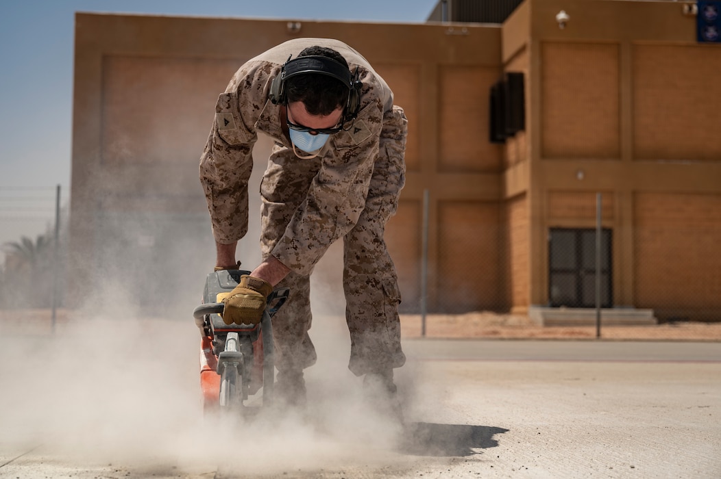 A U.S. Marine Corps combat engineer assigned to the 2nd Marine Logistics Group cuts concrete to repair the flightline at an undisclosed location within the U.S. Central Command area of responsibility, May 4, 2024. Total force integration focuses on creating a ready, willing and capable force to address global security challenges collectively. (U.S. Air Force photo)