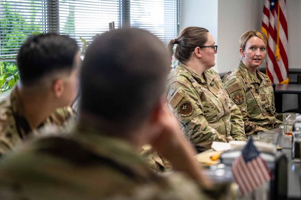 Wing commander listens to NCOs over a meal.