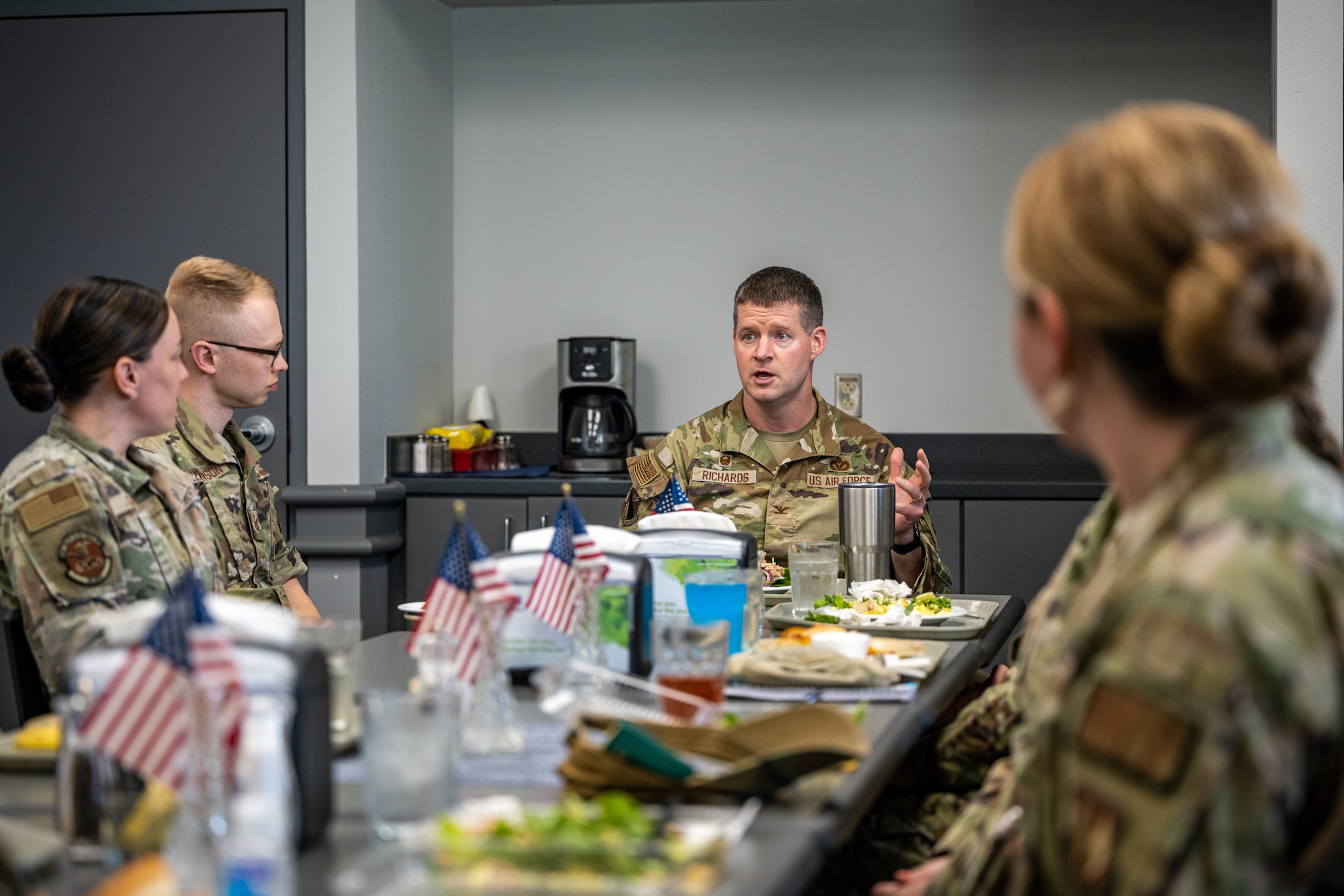 Wing commander speaks with NCOs over a meal.