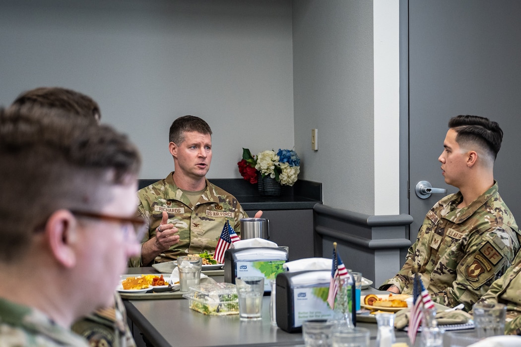 Wing commander speaks with NCOs over a meal.