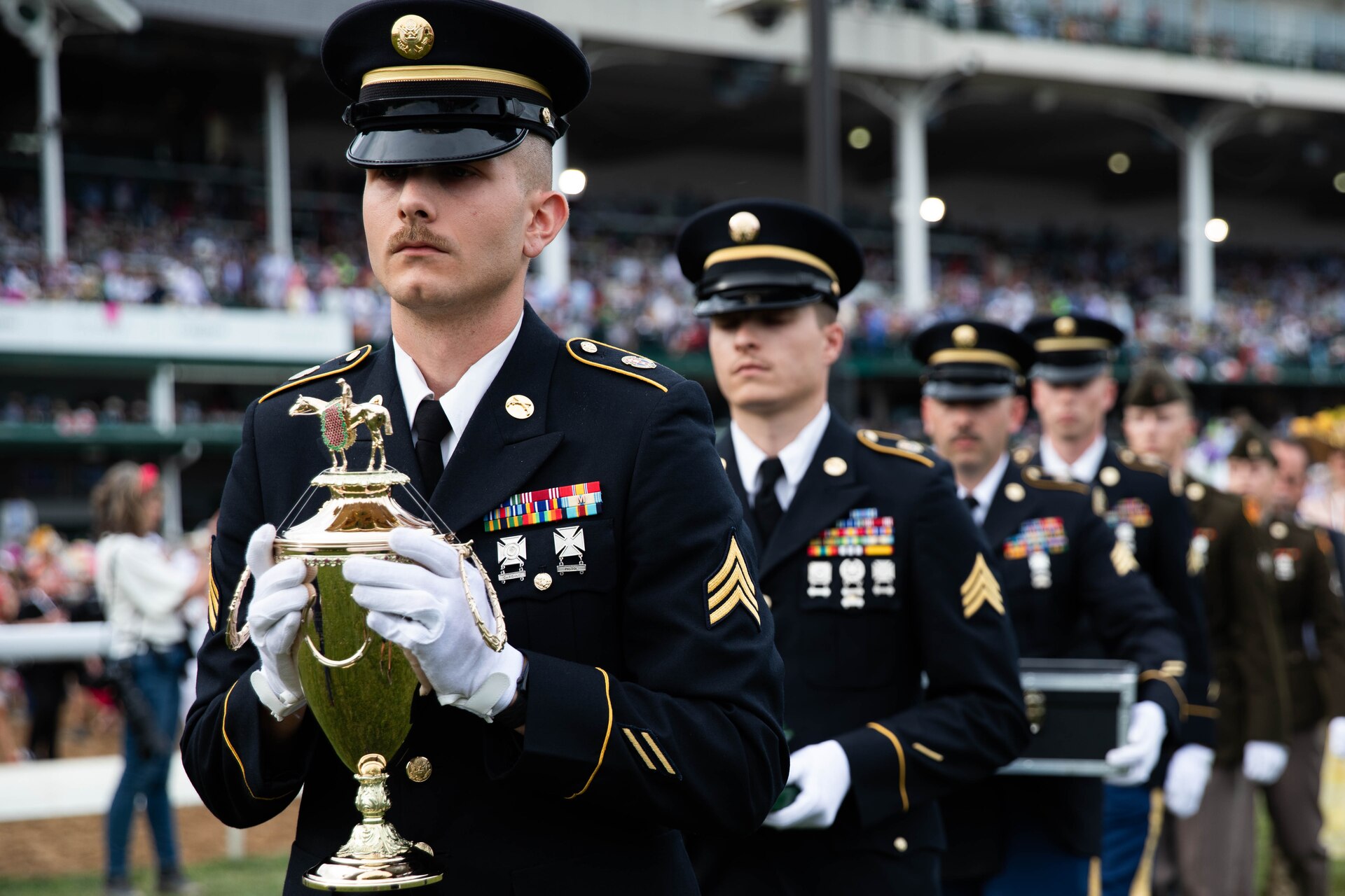 Soldiers of the 940th Military Police Company, 149th Maneuver Enhancement Brigade guard the winner’s trophy at the 150th Kentucky Derby at Churchill Downs, Louisville, Kentucky, May 4, 2024. The Kentucky Army National Guard carries a long tradition of escorting the winner’s cup dating back decades. (U.S. Army National Guard photo by Sergeant Caleb Sooter)