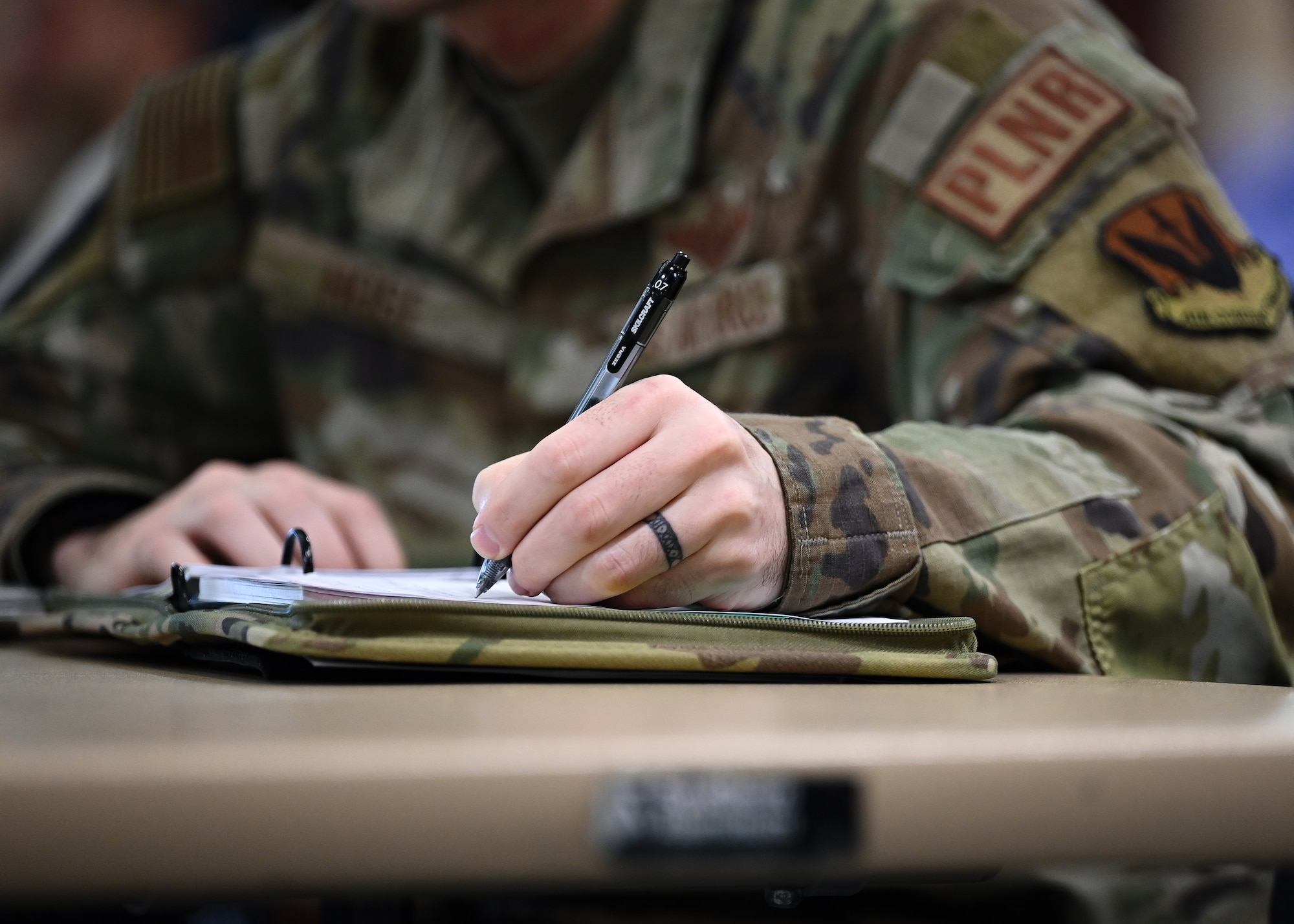 Airman takes notes during the Rapid Mobility Planning Conference