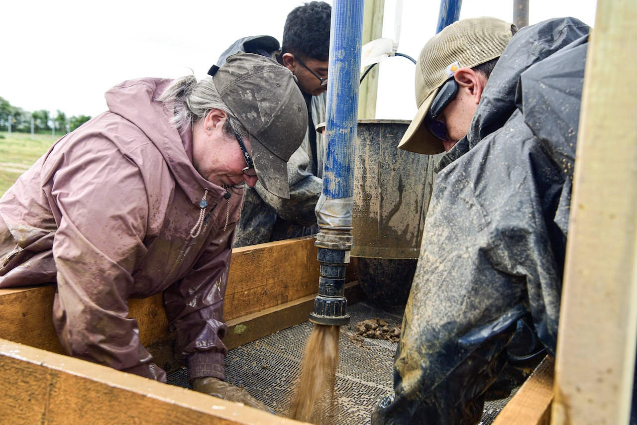 People sift through dirt at an excavation site.