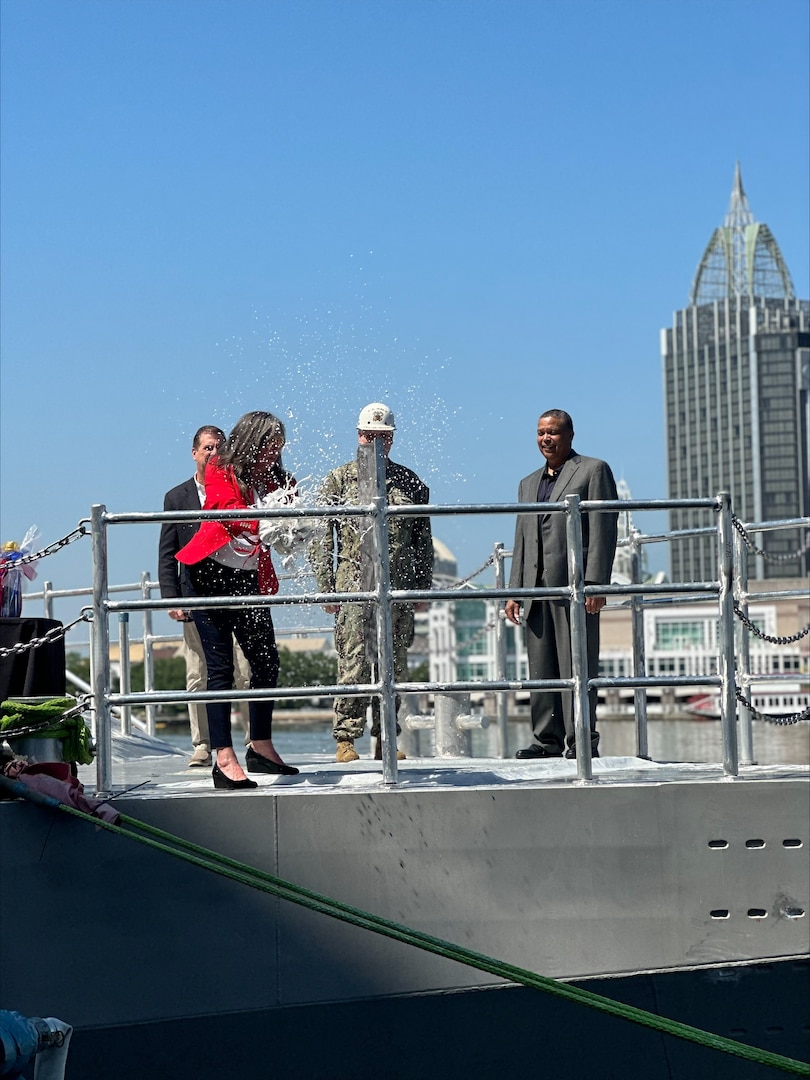 Mrs. Debbie Kennedy, Vanguard’s sponsor and wife of Capt. Scot Searles, Unmanned Maritime Systems Program Manager, breaks a bottle of champagne during the Vanguard christening ceremony, 25 April.