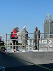 Mrs. Debbie Kennedy, Vanguard’s sponsor and wife of Capt. Scot Searles, Unmanned Maritime Systems Program Manager, breaks a bottle of champagne during the Vanguard christening ceremony, 25 April.