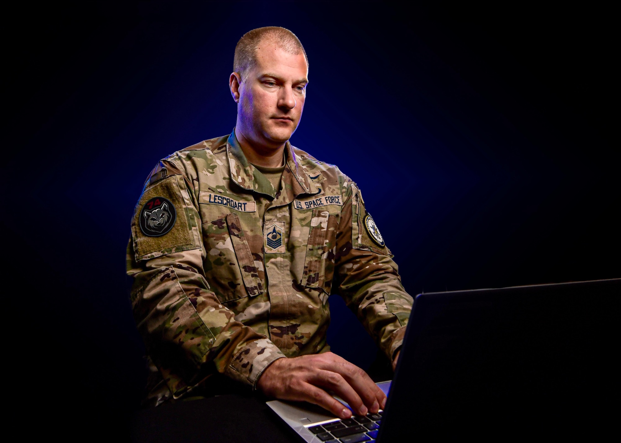 U.S. Space Force Master Sgt. Stephen Lescroart poses for a photo with a laptop.