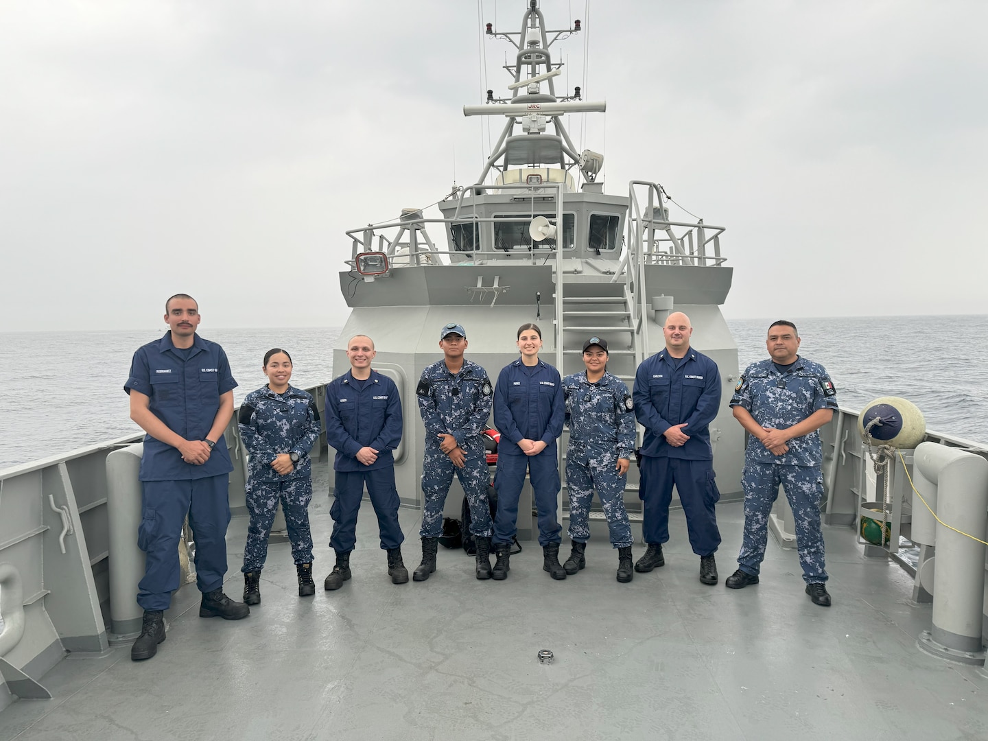 Crew members from U.S. Coast Guard Cutter Diligence (WMEC 616) and Mexican navy patrol vessel ARM Chichen Itza (PC 340) pose for a group photo, March 5, 2024, while conducting a passenger exchange on the International Maritime Boundary in the Gulf of Mexico. Both vessels were conducting patrols to combat illegal, unreported, and unregulated fishing (IUU-F). (U.S. Coast Guard photo by Petty Officer 2nd Class Thor Cocchi)