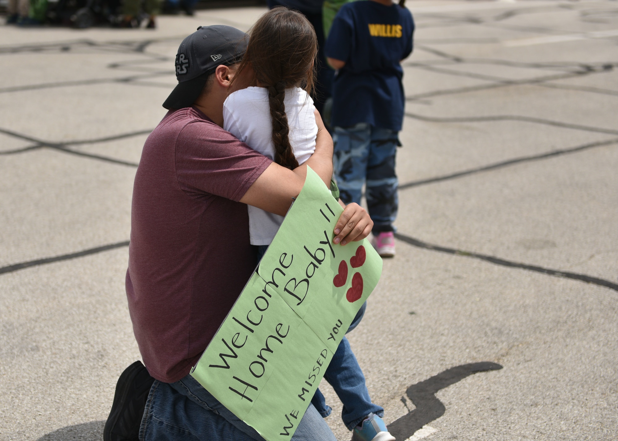 A family is reunited after Operation K.I.D.S. (Kids Investigating Deployment Services) at Goodfellow Air Force Base, Texas, April 27, 2024. Parents dropped off their kids with military members for the day and welcomed them back from deployment. (U.S. Air Force photo by 2nd Lt. Harris Hillstead)