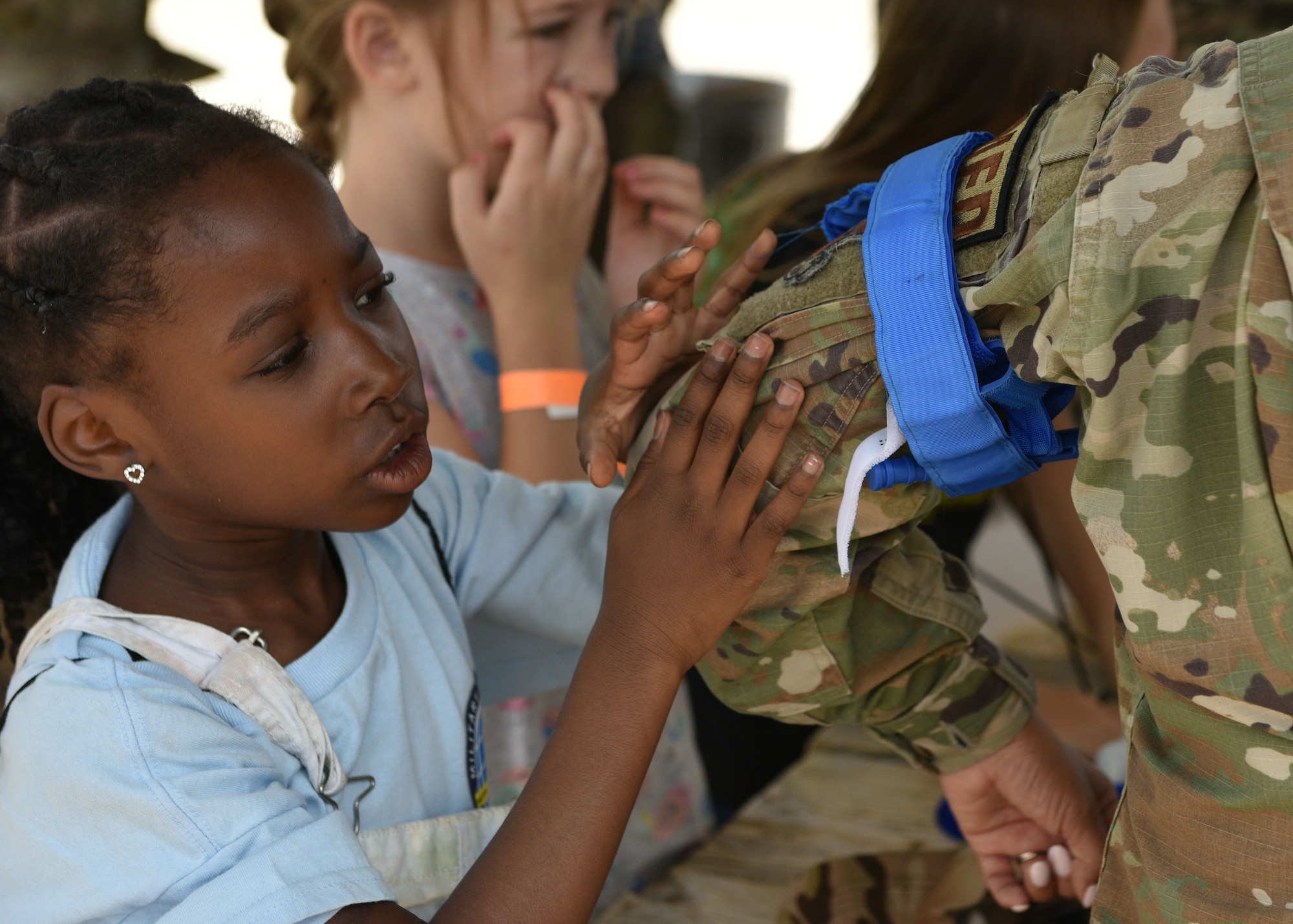 An Operation K.I.D.S. (Kids Investigating Deployment Services) participant fastens a tourniquet to a member of the 17th Medical Group at Forward Operating Base Sentinel, Goodfellow Air Force Base, Texas, April 27, 2024. Kids learned the basics of hand-to-hand combat, first aid, room clearing, and more as they simulated what deployed life might be like for their military parents. (U.S. Air Force photo by 2nd Lt. Harris Hillstead)