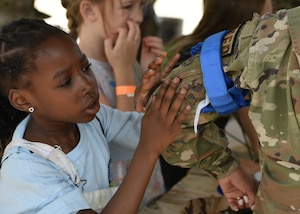 An Operation K.I.D.S. (Kids Investigating Deployment Services) participant fastens a tourniquet to a member of the 17th Medical Group at Forward Operating Base Sentinel, Goodfellow Air Force Base, Texas, April 27, 2024. Kids learned the basics of hand-to-hand combat, first aid, room clearing, and more as they simulated what deployed life might be like for their military parents. (U.S. Air Force photo by 2nd Lt. Harris Hillstead)