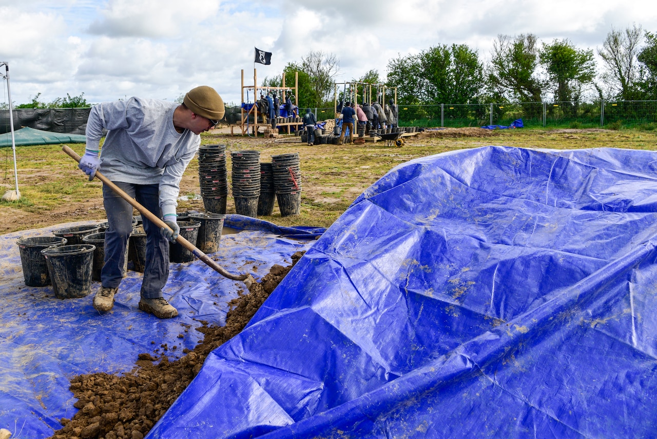 A man shovels dirt.
