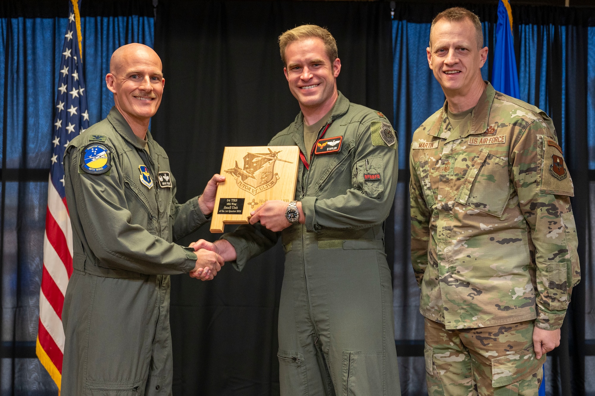 U.S. Air Force Maj. Kyle Rasmussen, 54th Training Squadron instructor pilot, accepts the 49th Wing’s Small Unit of the Quarter Award, during the 49th Wing’s 1st Quarter Award ceremony at Holloman Air Force Base, New Mexico, May 3, 2024. Quarterly award winners were selected based on their technical expertise, demonstration of leadership and job performance. (U.S. Air Force photo by Airman 1st Class Michelle Ferrari)